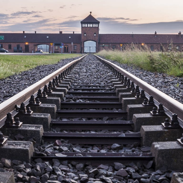 Ein Gleis führt Richtung Haupteingang des KZ Auschwitz