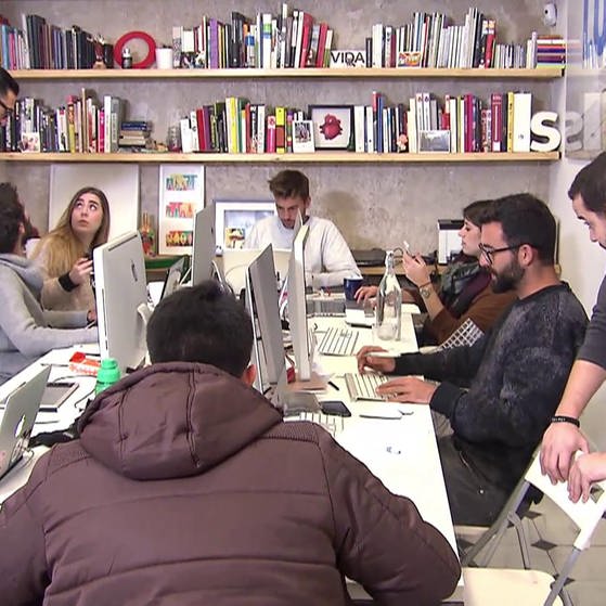 Mitglieder der Gruppe Boa Mistura um einen Arbeitstisch mit Laptops.