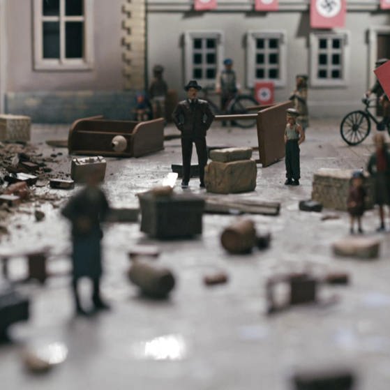 Modellwelt im Film: Zerstörungen an Häusern, überall hängen Hakenkreuz-Fahnen.