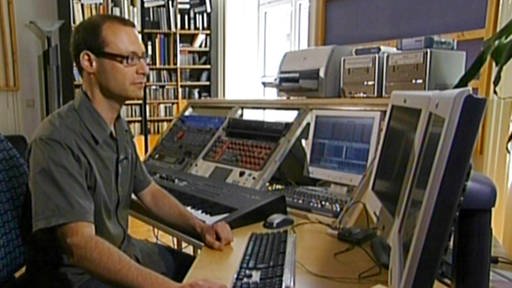 Filmkomponist Christian Kardeis sitzt vor vielen Monitoren