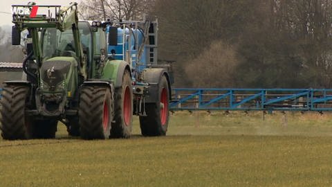 Ein Traktor sprüht Pestizide.