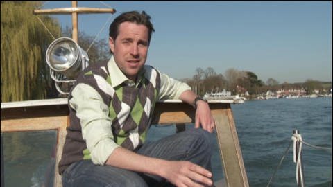 Ein Mann sitzt auf einem Boot und fährt damit über den River Thames.