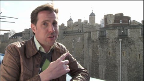 Ein Mann steht vor dem Tower of London.