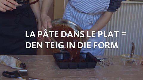 Kuchenteig wird in eine Backform gefüllt, davor der Schriftzug "La pâte dans le plat = den Teig in die Form".