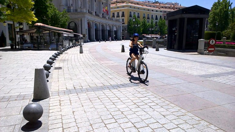 Eine Straße in Madrid mit einer Radfahrerin.