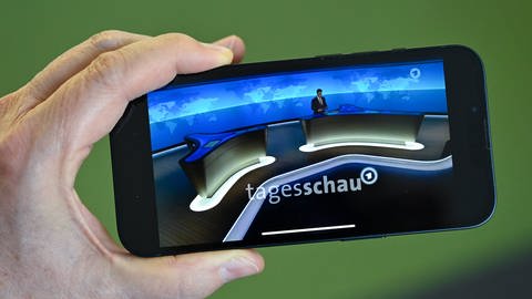 Ein Smartphone mit Tagesschau-Sprecher, Constantin Schreiber, auf der Tagesschau-App.