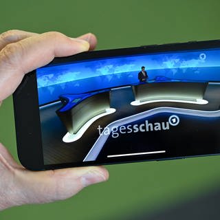 Ein Smartphone mit Tagesschau-Sprecher, Constantin Schreiber, auf der Tagesschau-App.
