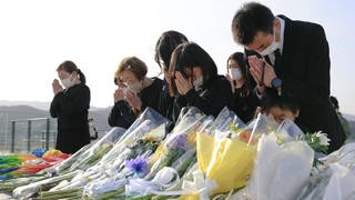 Menschen beten und trauern um die Opfer des Tsunami in Japan 2011.