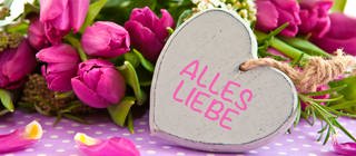 Blumen und ein Herz mit der Aufschrift "Alles Liebe"