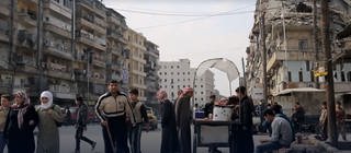 Menschen auf den Straßen einer zerstörten Stadt in Syrien - seit Jahren herrscht dort ein Bürgerkrieg. 