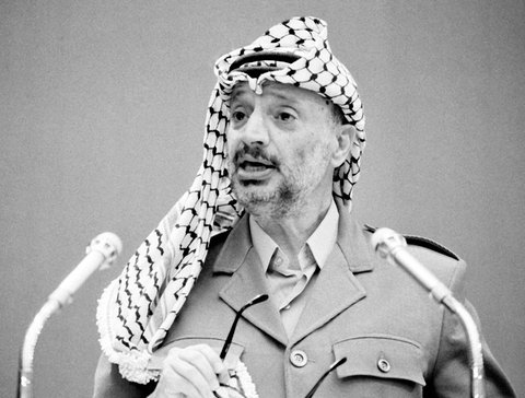 Jassir Arafat, der ehemalige Vorsitzende der PLO, steht vor zwei Mikrofonen