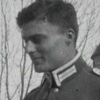Ein uniformierter Soldat auf einem schwarz-weiß Bild.
