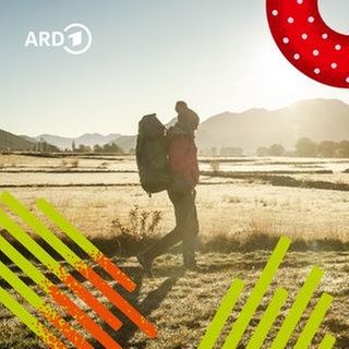 Ein Mensch wandert mit einem Rucksack bepackt durch die Landschaft