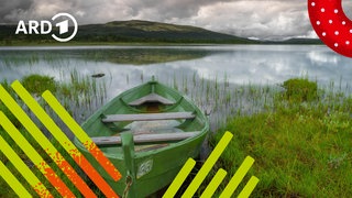 Ein Boot liegt am Ufer eines Sees mit ruhigem Wasser