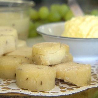 Kleine Handkäse mit Kümmel, drapiert auf einem Tisch mit Trauben