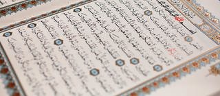 Aufgeschlagener Koran mit arabischer Schrift