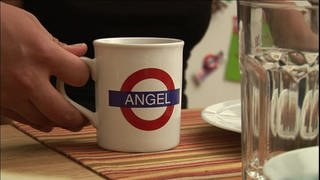 Ein weißer Becher mit dem Schriftzug "Angel" in Form des englischen U-Bahn-Schilds.