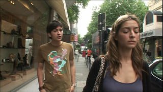 Ein junger Mann und eine junge Frau laufen durch die Stadt und streiten.