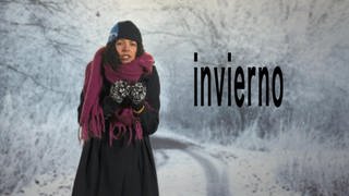 Eine Frau steht auf einer schneebedeckten Straße. Sie trägt dicke Winterkleidung. Neben ihr der Schriftzug "invierno".