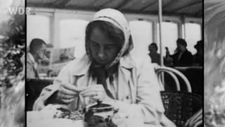 Schwarz weiß Fotografie von Irmgard Keun, sie sitzt in einem Café, schaut nach unten und trägt ein Kopftuch.