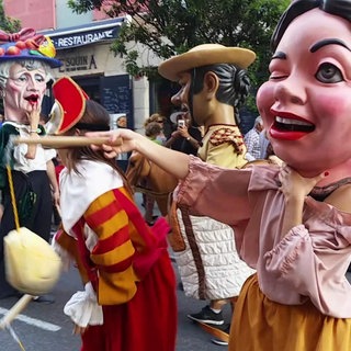 Menschen in Puppen-Verkleidungen bei einer Parade.