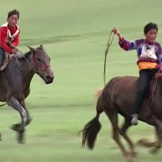 Zwei monogolische Jungen treiben ihre Pferde Argentinien