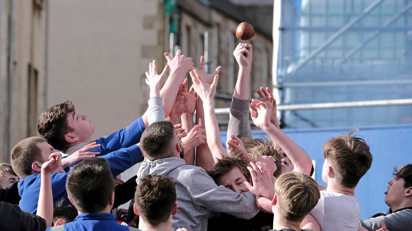 Jugendliche in Jedburg, Schottland, kämpfen nach dem Einwurf um den Ba genannten Lederball.